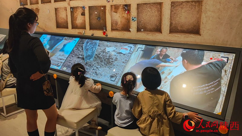 家长带领孩子观看考古纪录影像。人民网 党童摄